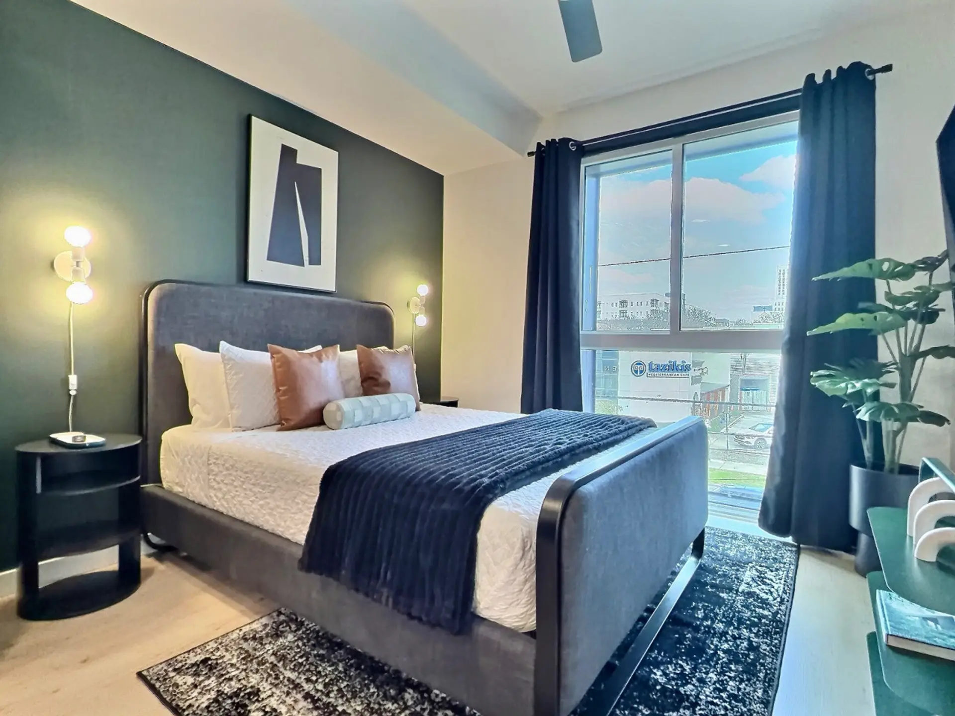Relax in a cozy bedroom with city views inside a furnished apartment..