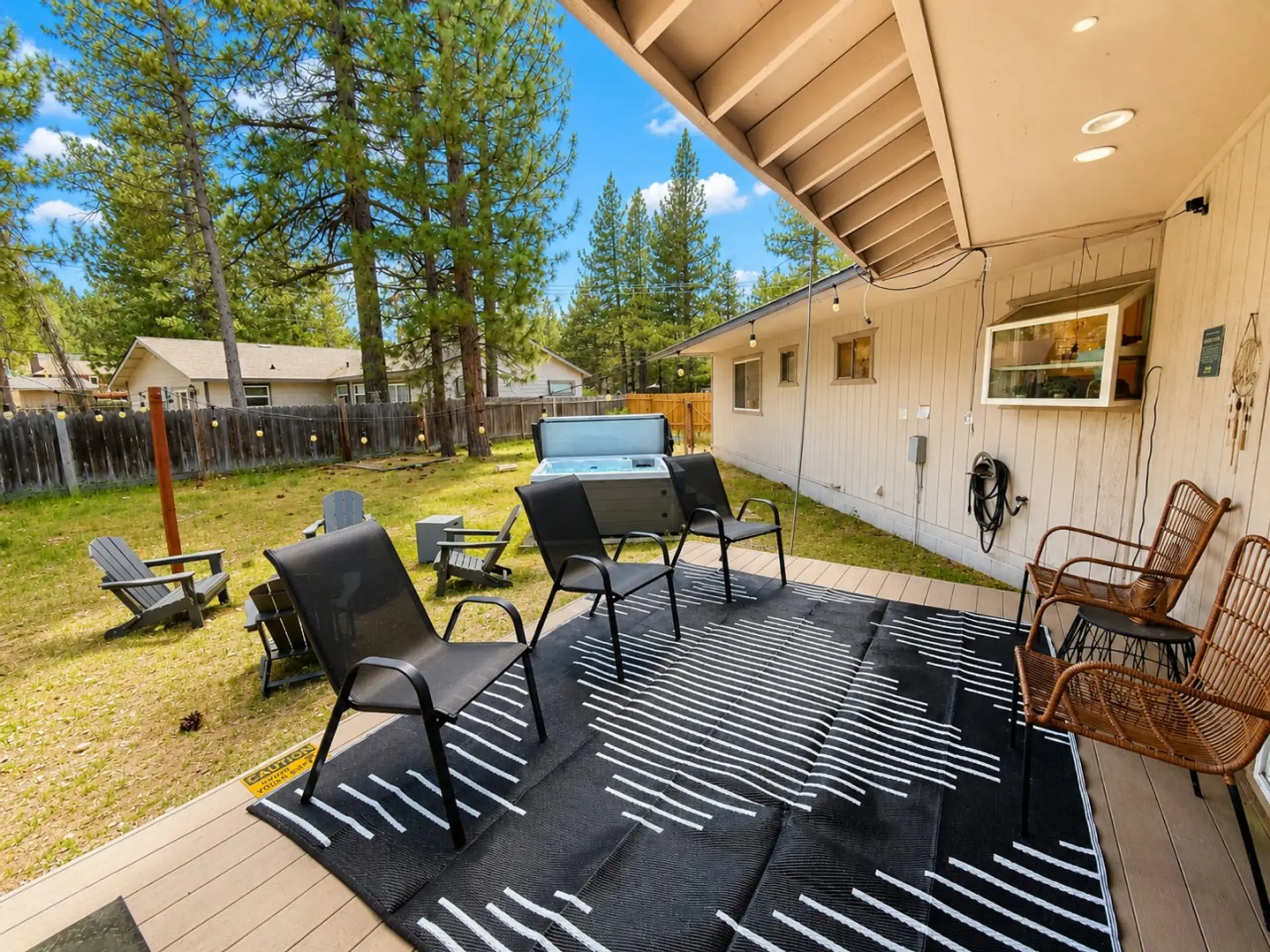 Back deck in Spring with firepit & hot tub in the backgound