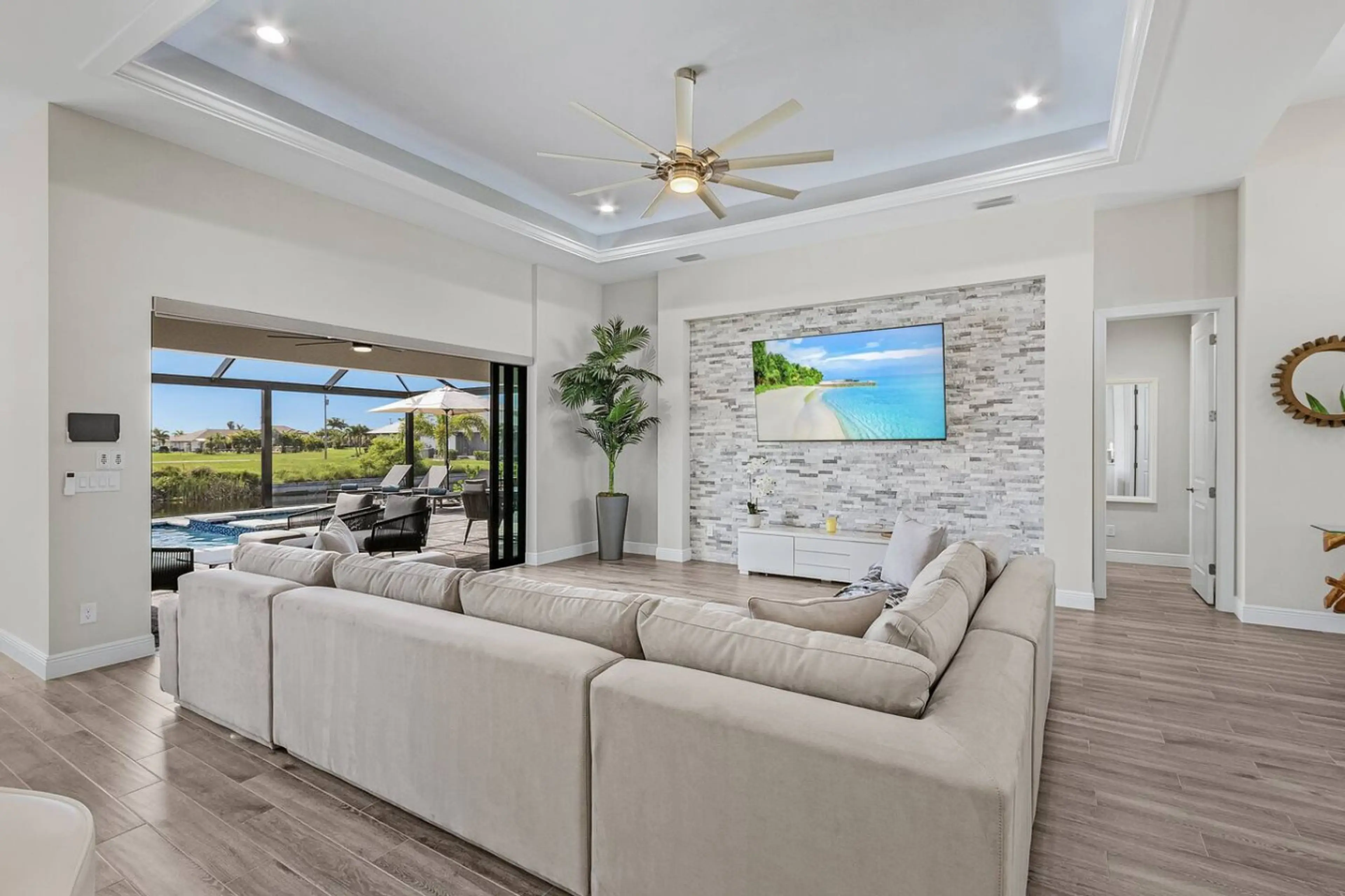 Bright, airy living room with cozy seating and large TV, perfect for relaxation.