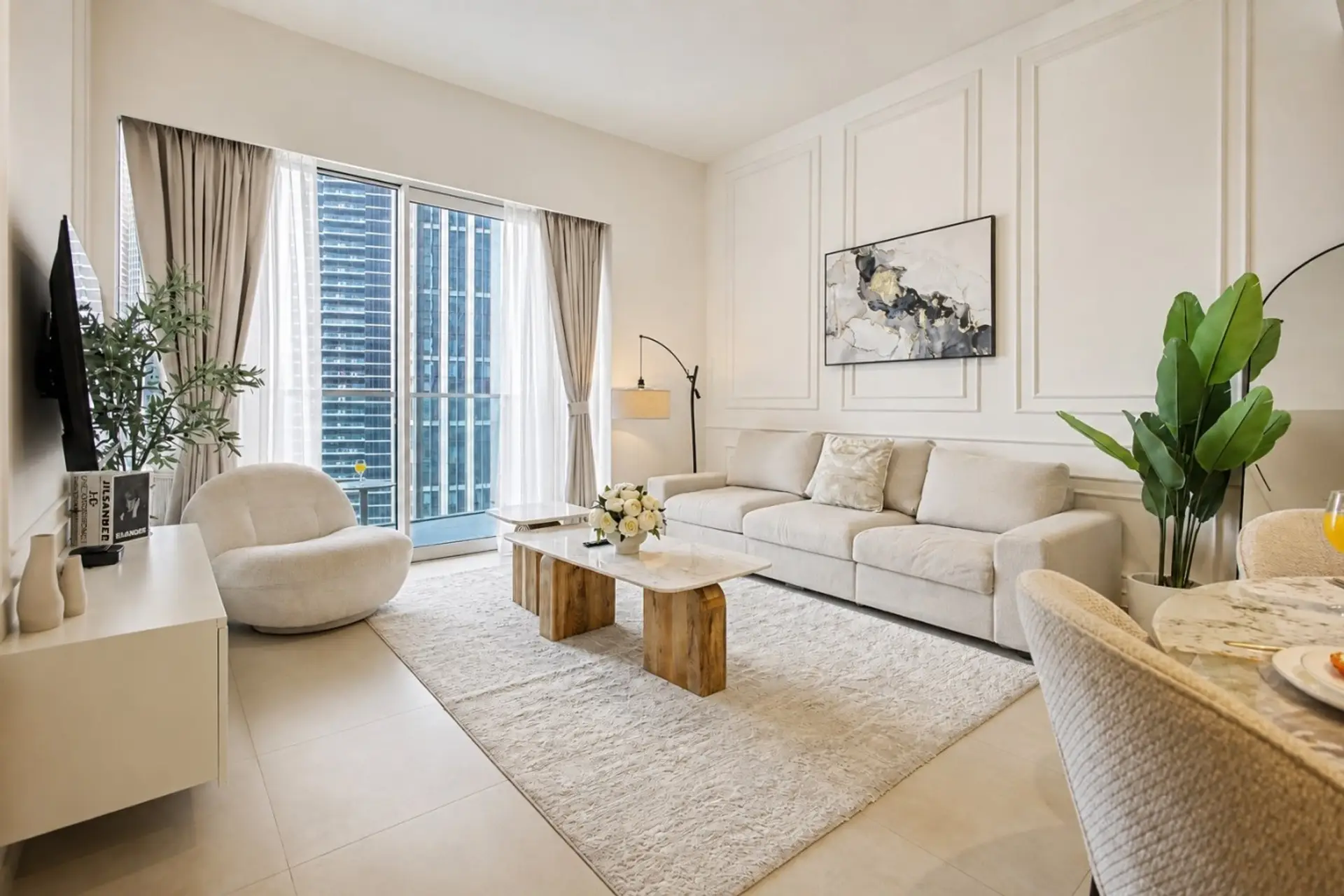 Flexible living space with a sofa bed, marble console, and floor-to-ceiling skyline views. The convertible layout makes it practical for solo travelers or couples needing an extra sleeping area.