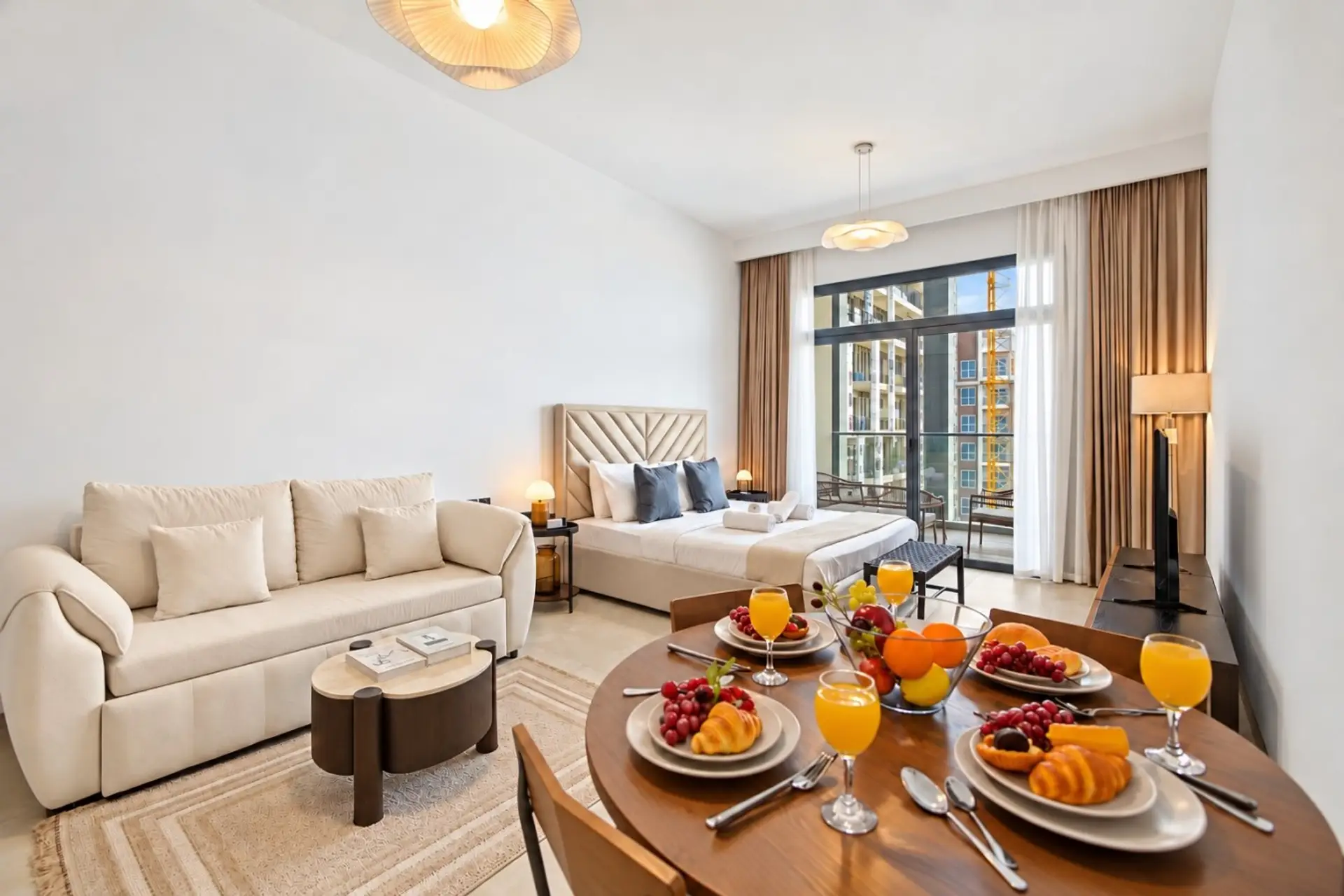 Living room corner with a marble coffee table, white orchid centerpiece, plush sofa, and a warm arc floor lamp beside floor-to-ceiling windows. Soft, curated details that make the space feel lived-in and welcoming.