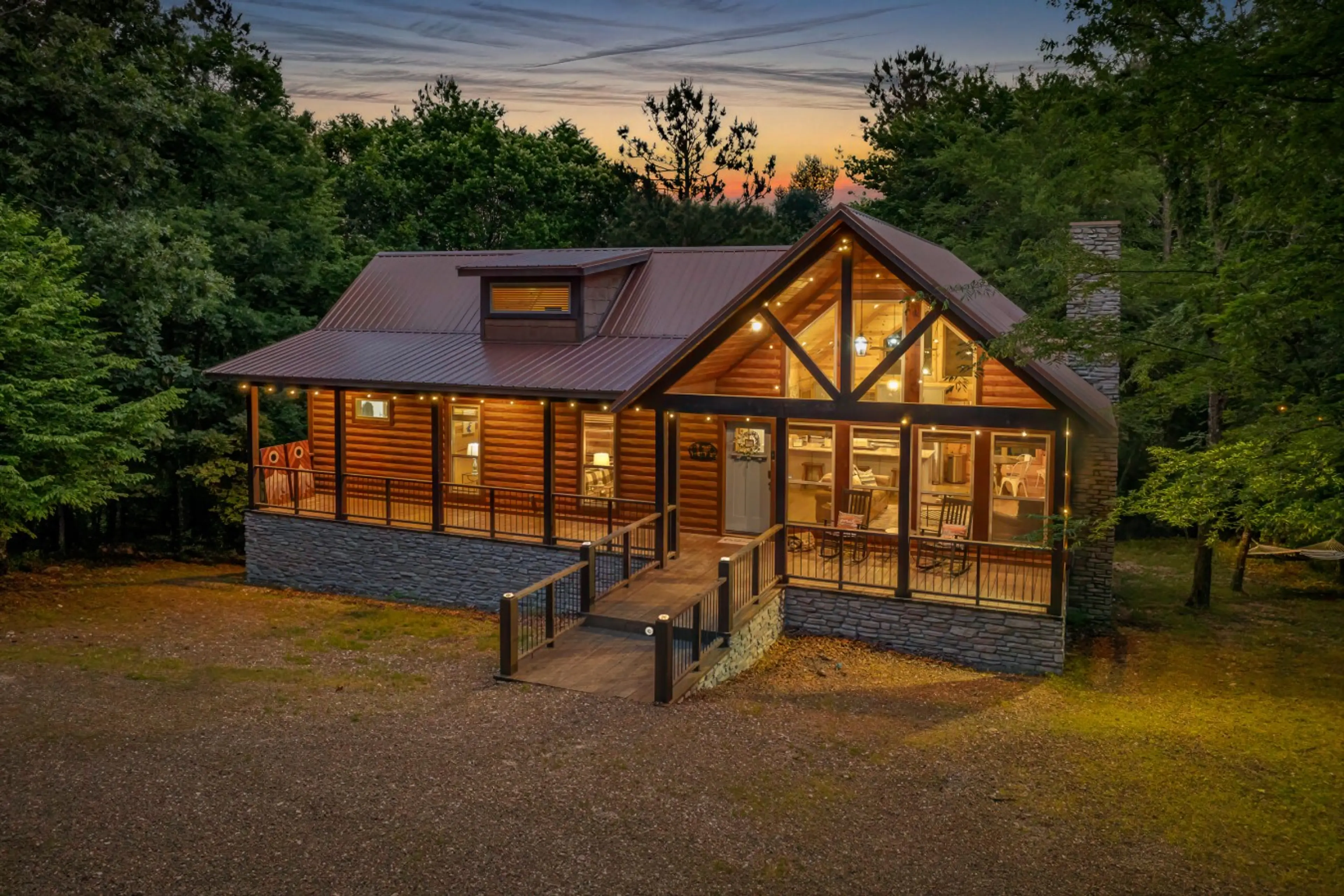 Cabin exterior at golden hour — A-frame facade and warm string lights