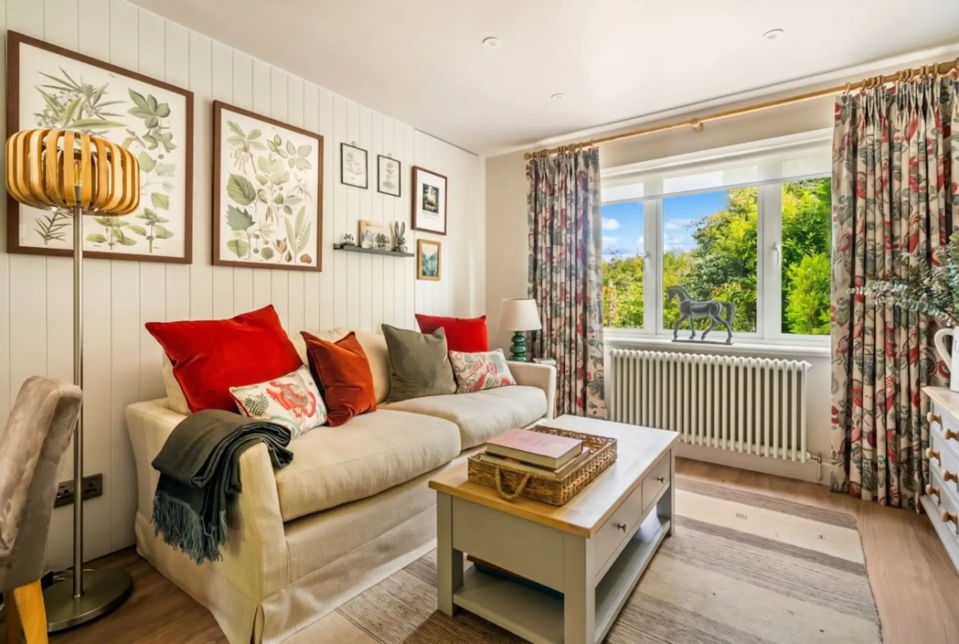 Bright sitting room with garden views and a curl-up sofa.