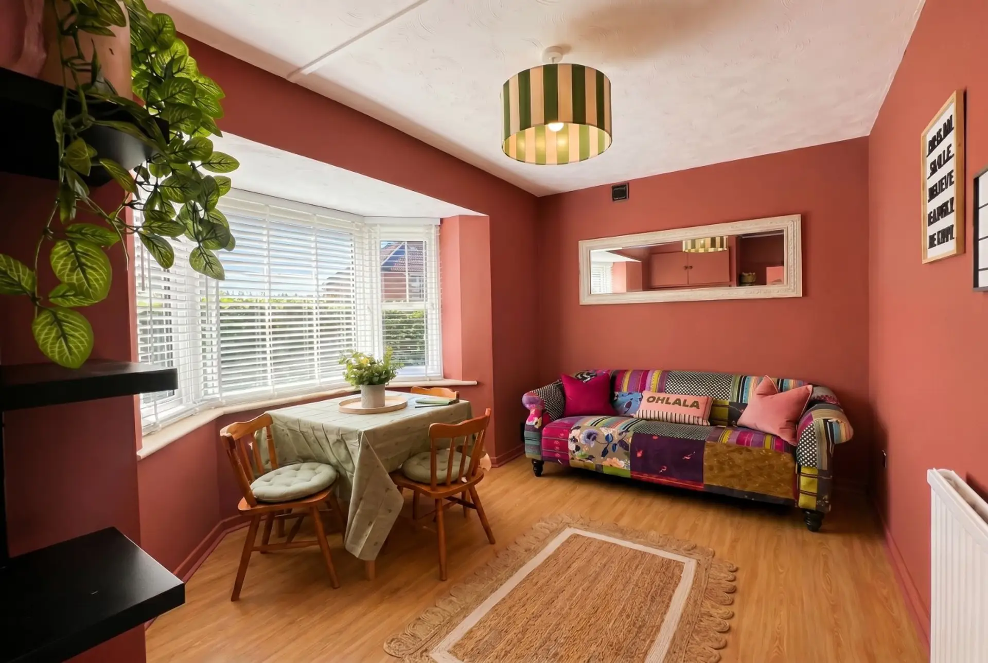 Bold patchwork sofa and bay window make this living room impossible to forget.