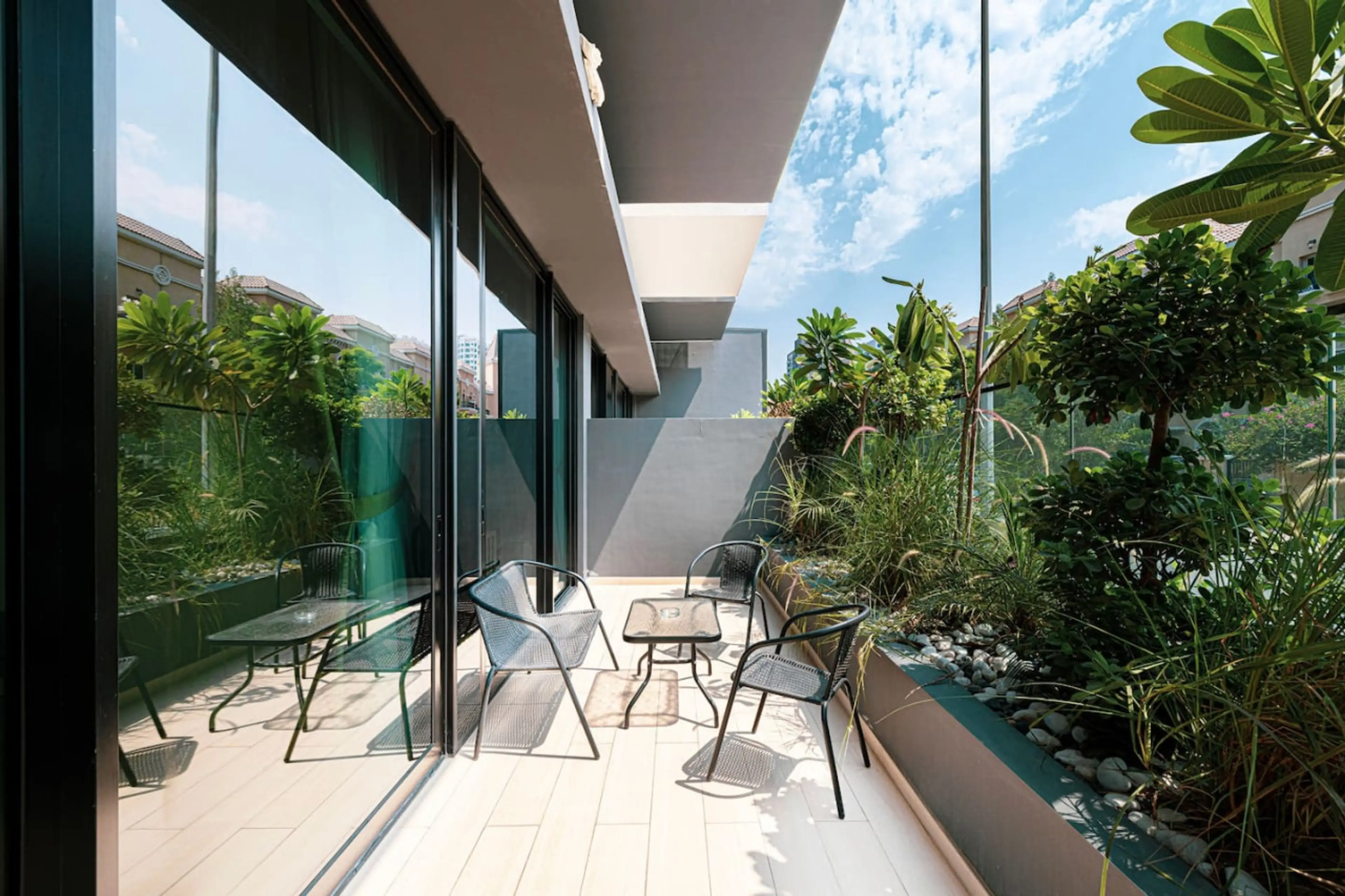 Private garden terrace with cozy seating, surrounded by lush greenery.